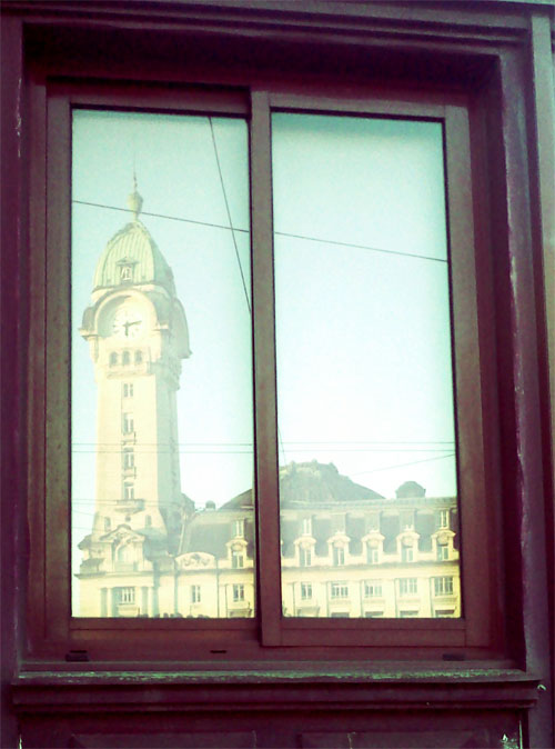 photographie du reflet de la gare de limoges bénédictins sur une fenêtre